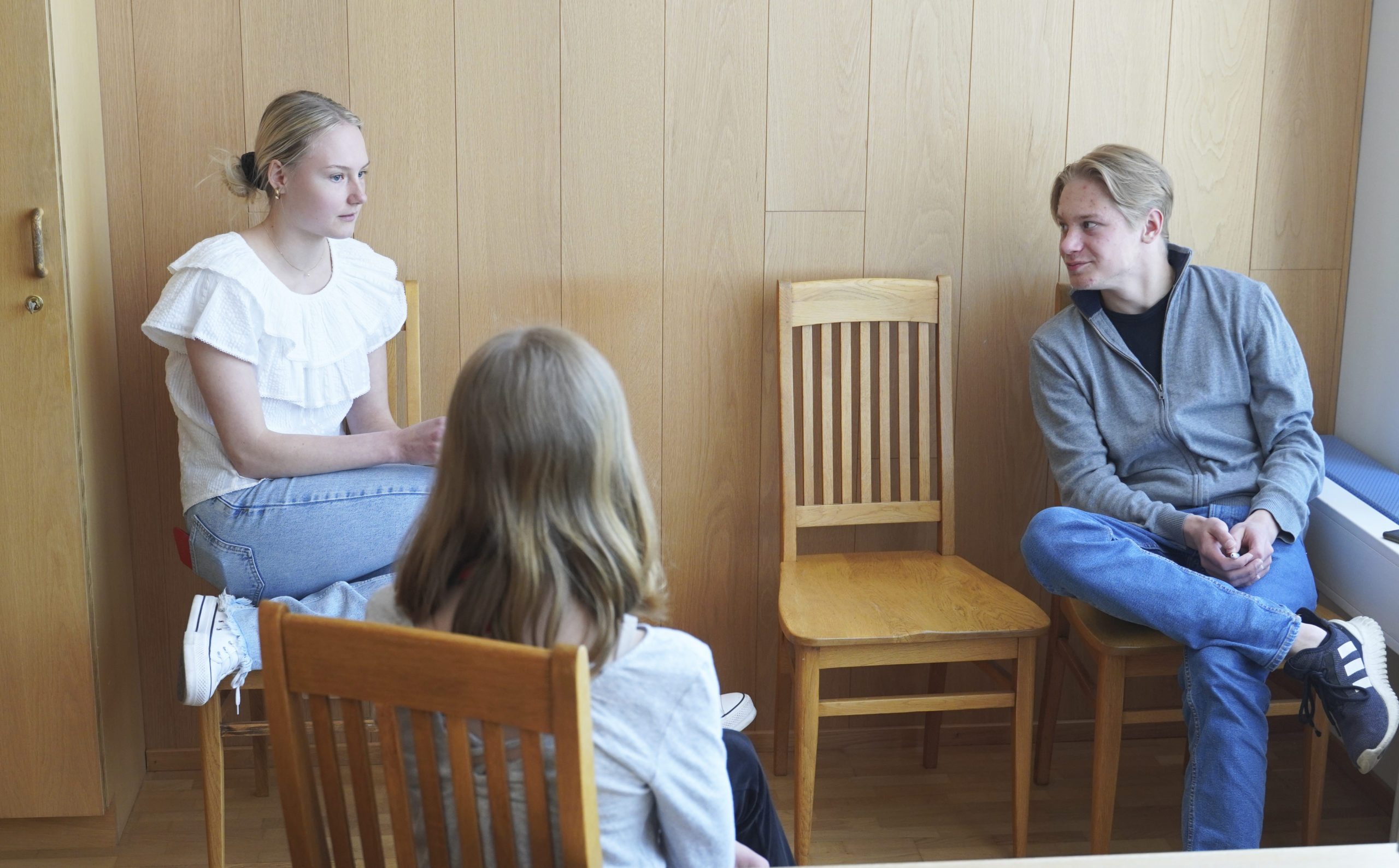 Kolme nuorta keskustelee ryhmässä.